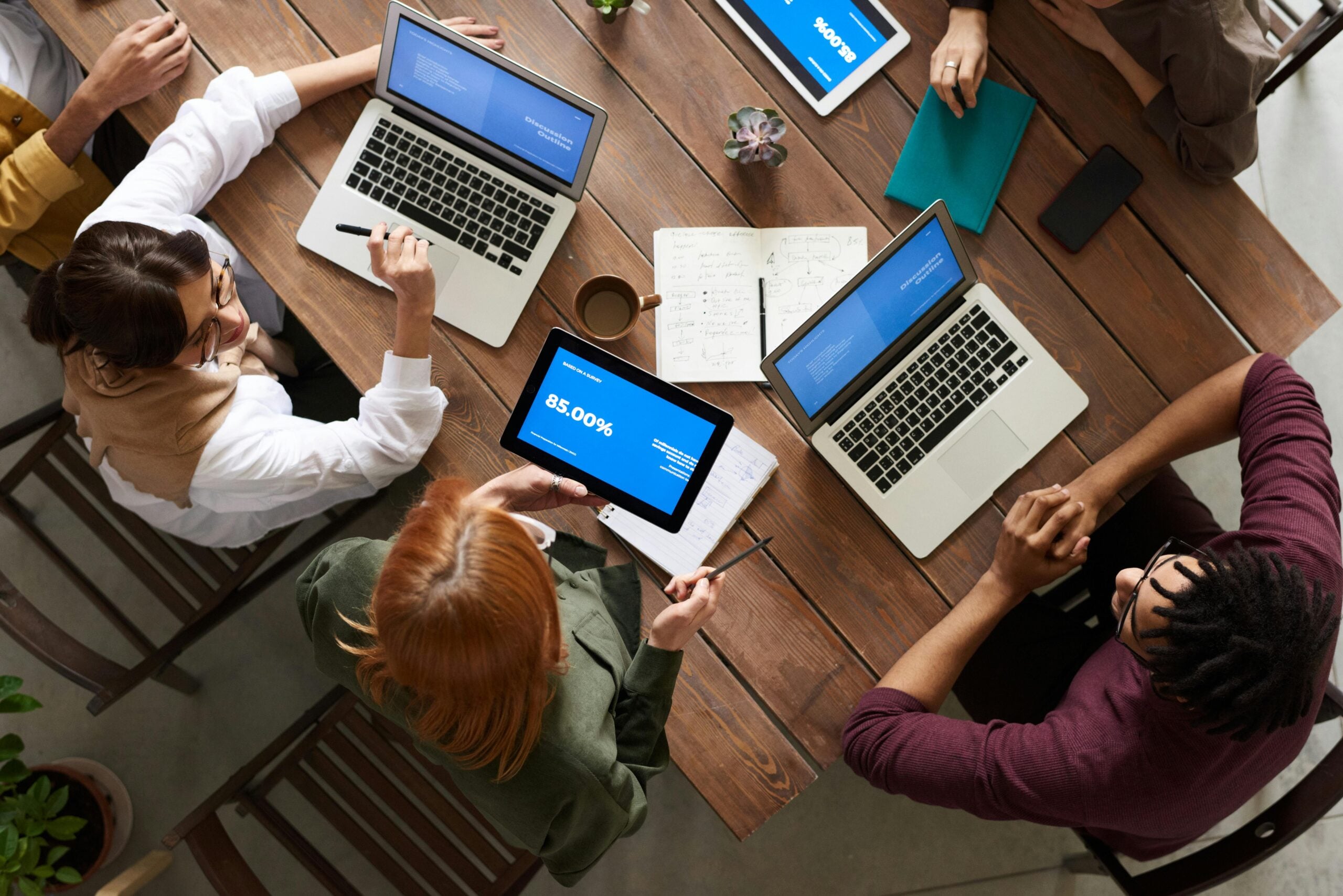 A team reviewing documents and devices around a table, representing regulatory due diligence on a regulated target