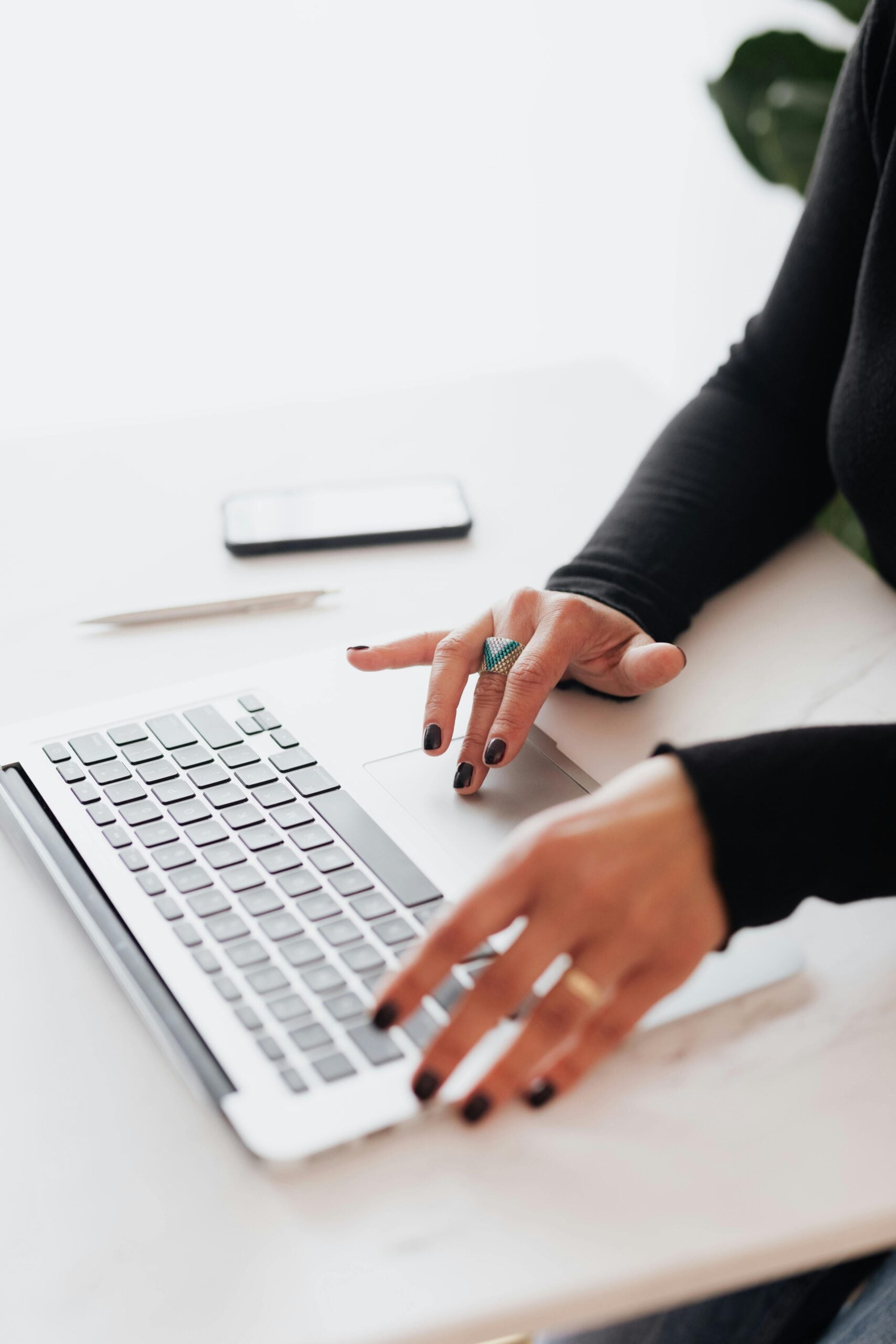 Hands at a keyboard beside a pen and paper, representing commercial and technology contract support