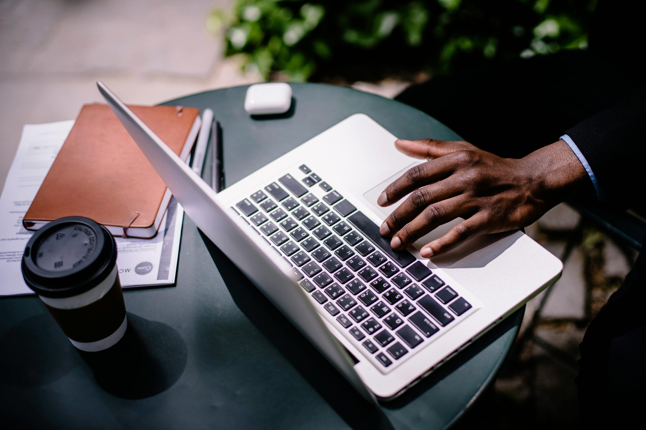 A person working at a laptop with a coffee, representing advice on payments products, safeguarding and scheme governance